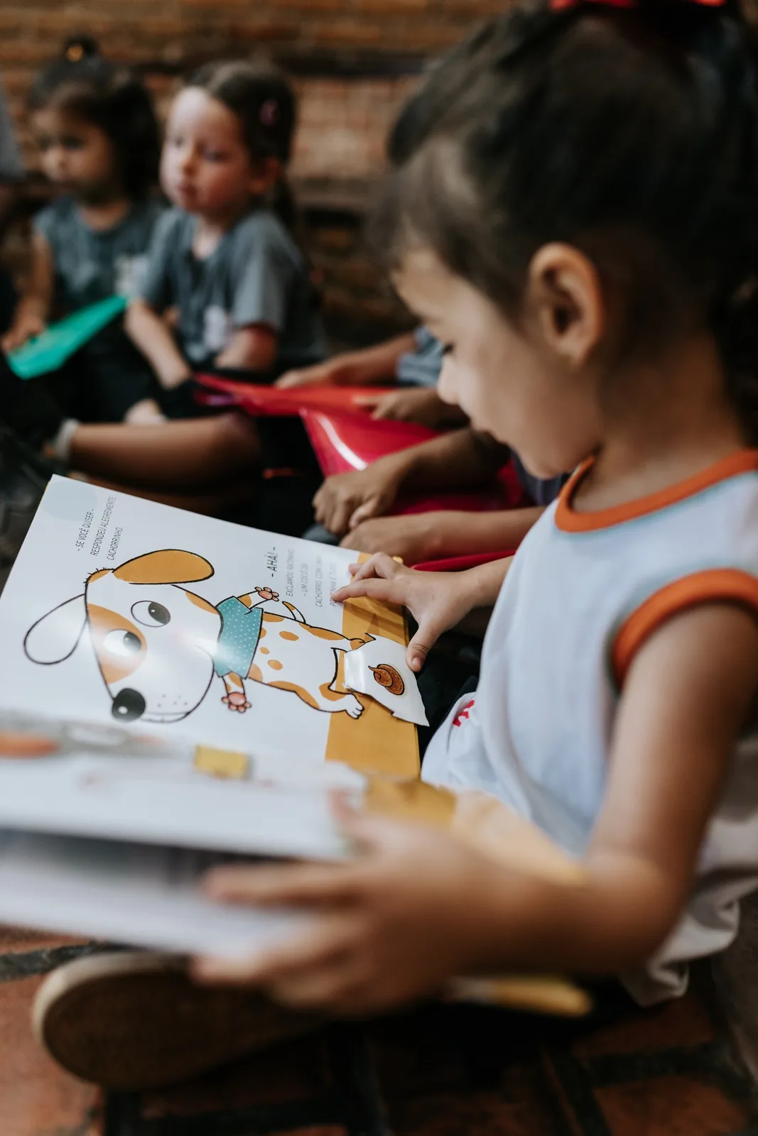 Crianças da Educação Infantil explorando livros ilustrados